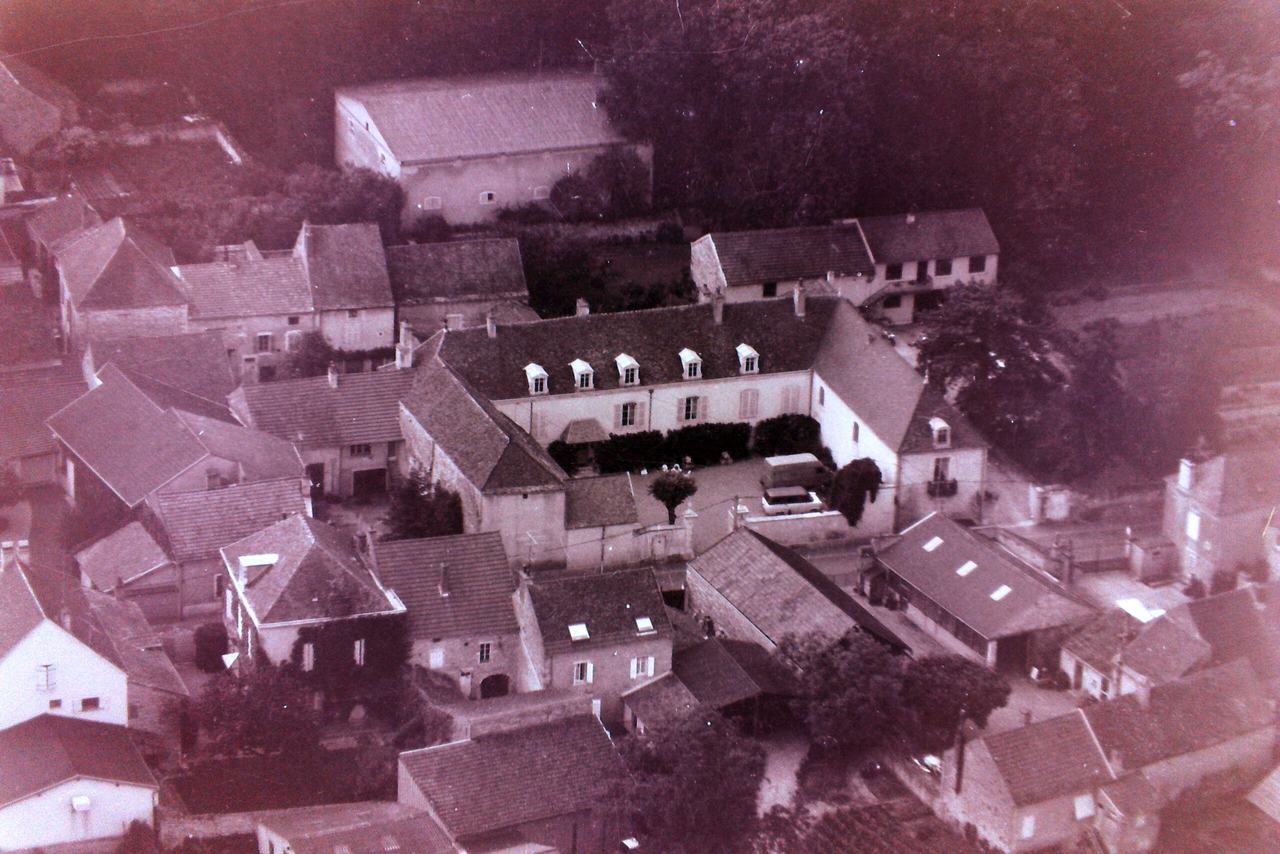 An old aerial photograph of the domaine's buildings among the rooftops of Meursault.