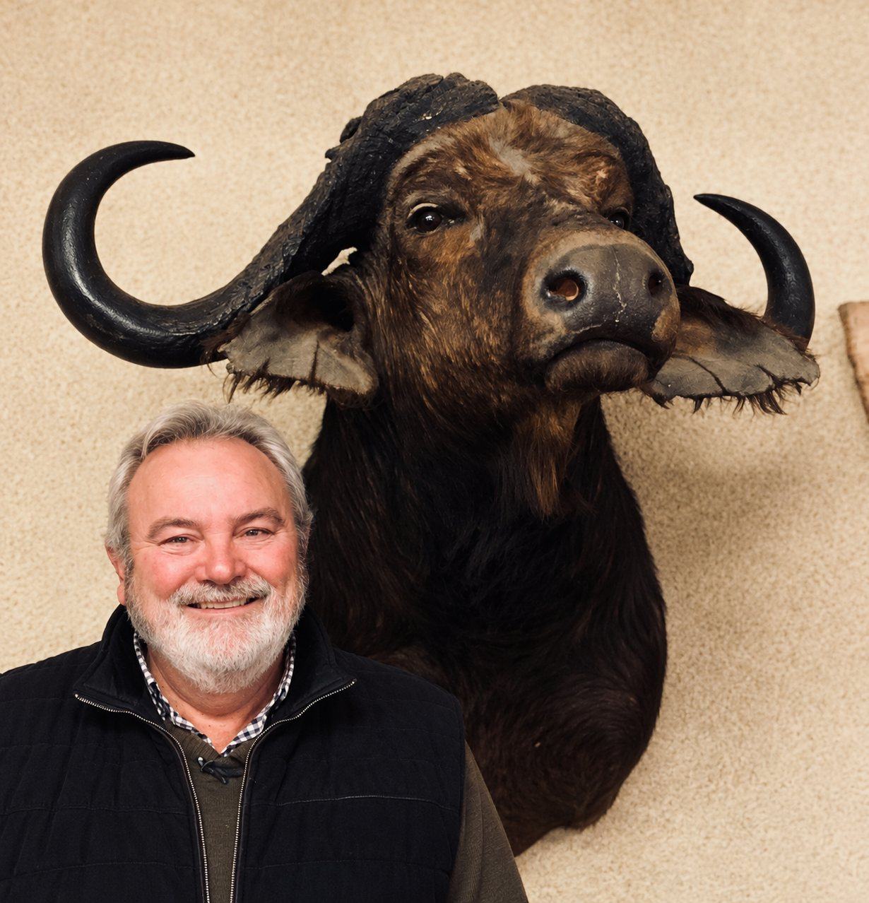 José Dhondt smiling beneath a mounted buffalo head