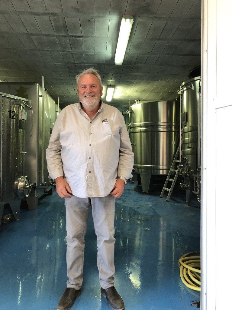 José Dhondt standing among the stainless-steel tanks in his cuverie at Oger