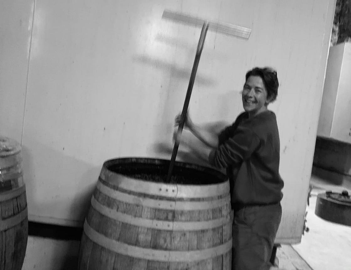Mathilde punching down the cap in an open barrel in the cellar