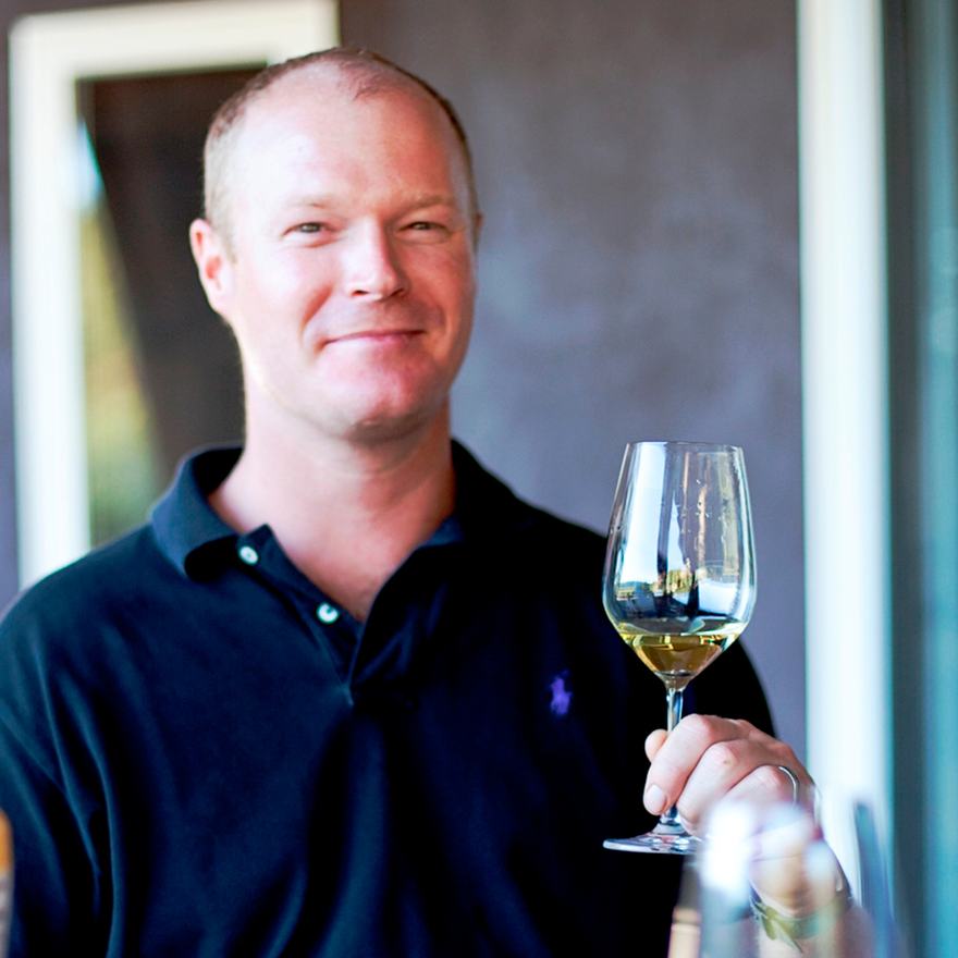 Kirk Venge holding a glass of white wine.
