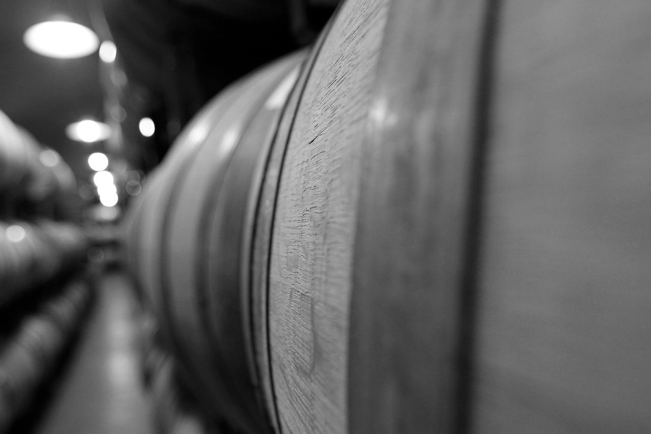 A row of barrels in a dim cellar, close up