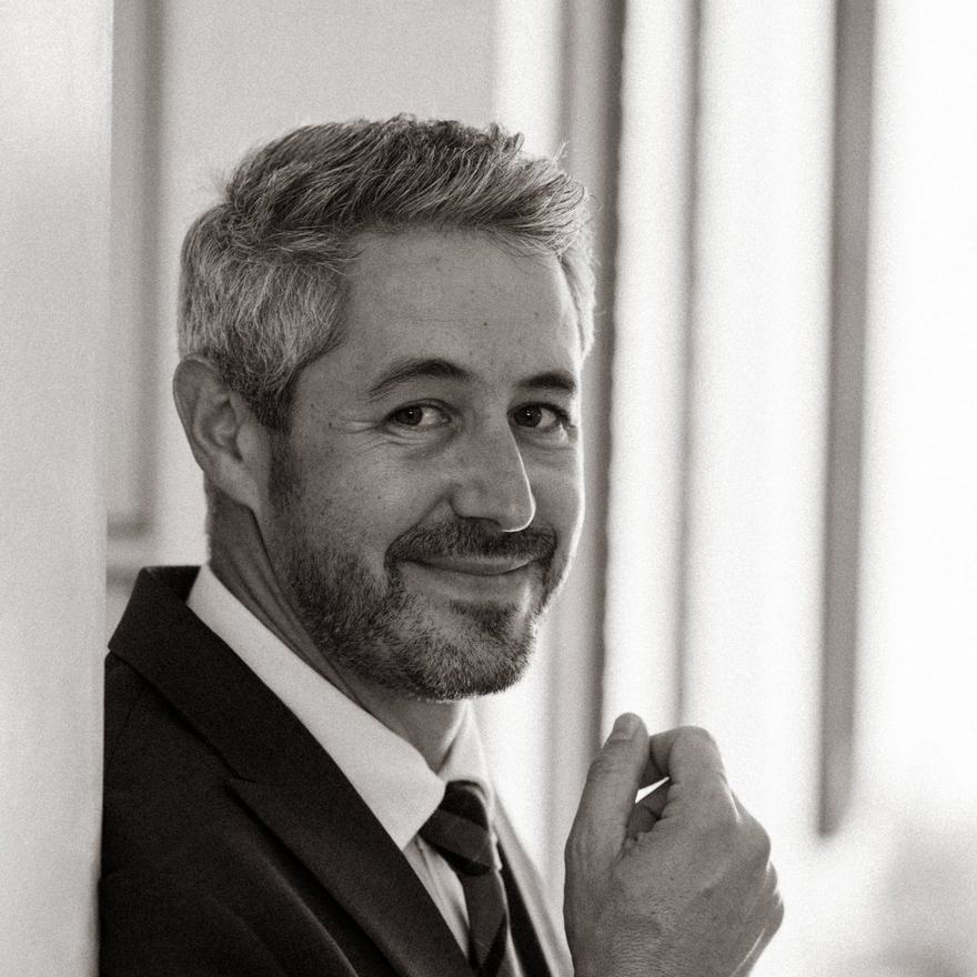 Black-and-white portrait of a smiling man in a suit and tie