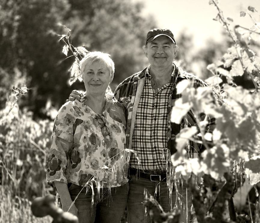Rémy and Martine Pédréno standing together among the vines, in black and white.