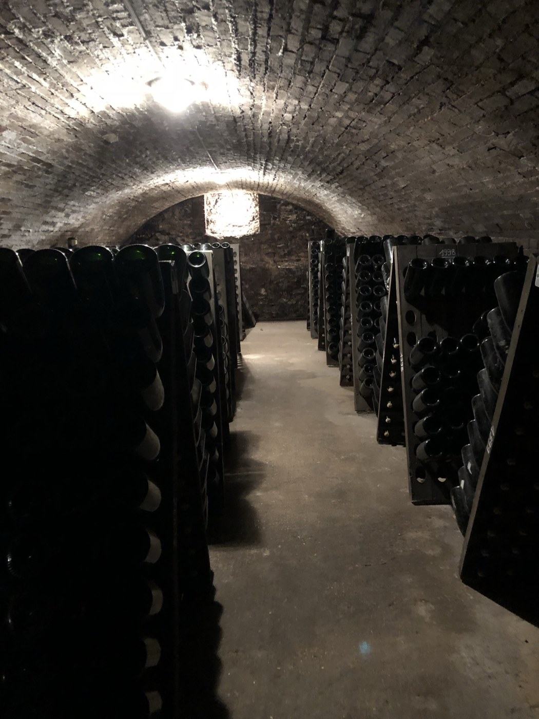 The brick-vaulted cellar at Vazart-Coquart in Chouilly, bottles riddling in wooden pupitres down both sides, a rack marked 1998