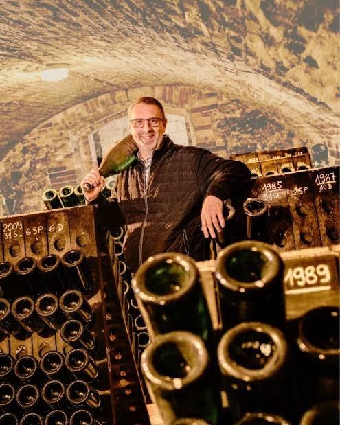 Jean-Pierre Vazart in the cellar at Chouilly, a bottle over his shoulder, among racks of old vintages marked 1985, 1987 and 1989